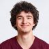 Positive male youngster with curly hair, looks joyfully at camera, has gentle smile, dressed in casual outfit, spends free time with girlfriend, isolated over white background. People and lifestyle